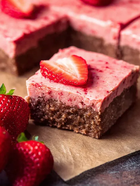 Kawałek brownie z truskawką na wierzchu.