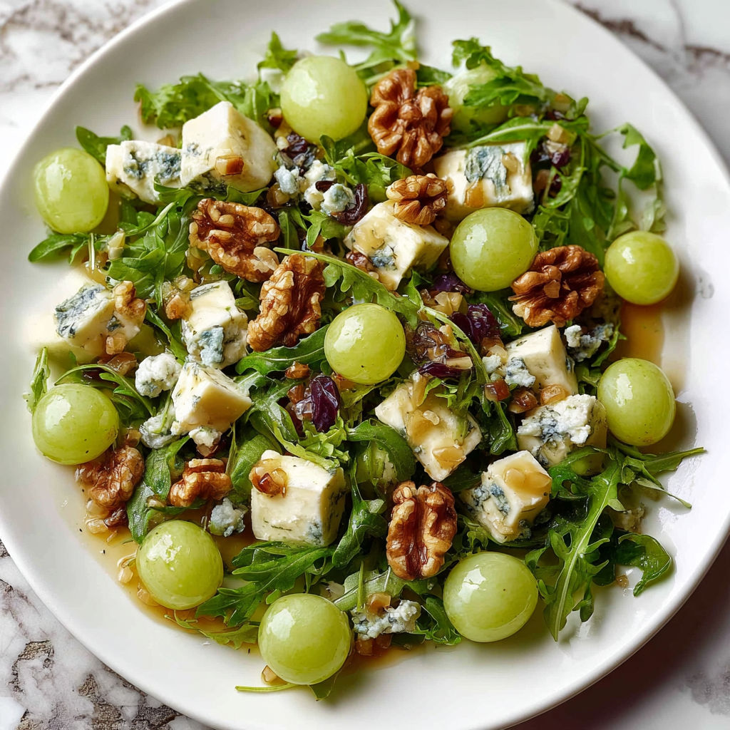 A plate of salad with grapes, walnuts, and blue cheese.