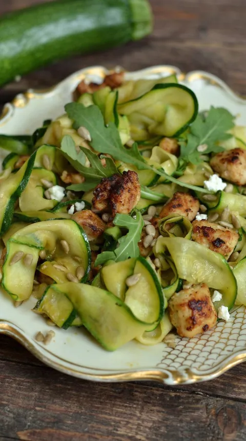 A plate of food with chicken and zucchini.