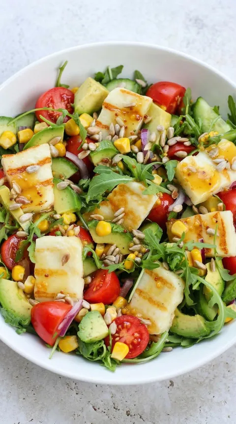 A salad with tomatoes, corn, and cheese.