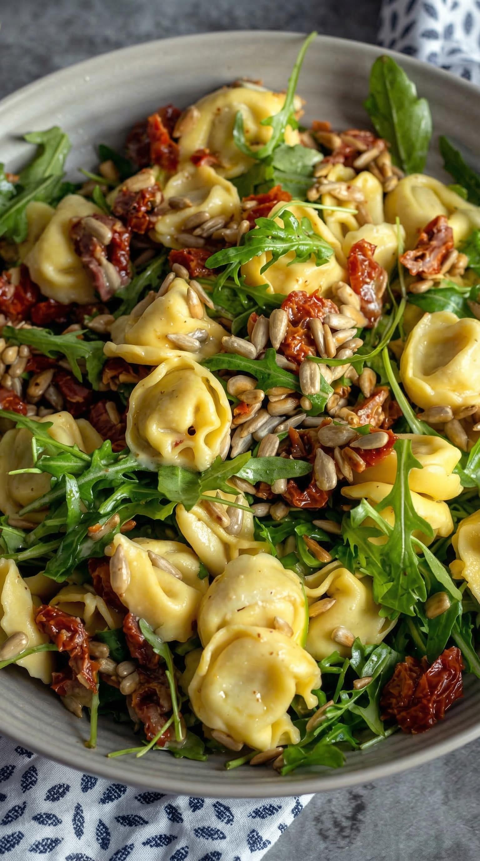 A plate of pasta with pine nuts and tomatoes.