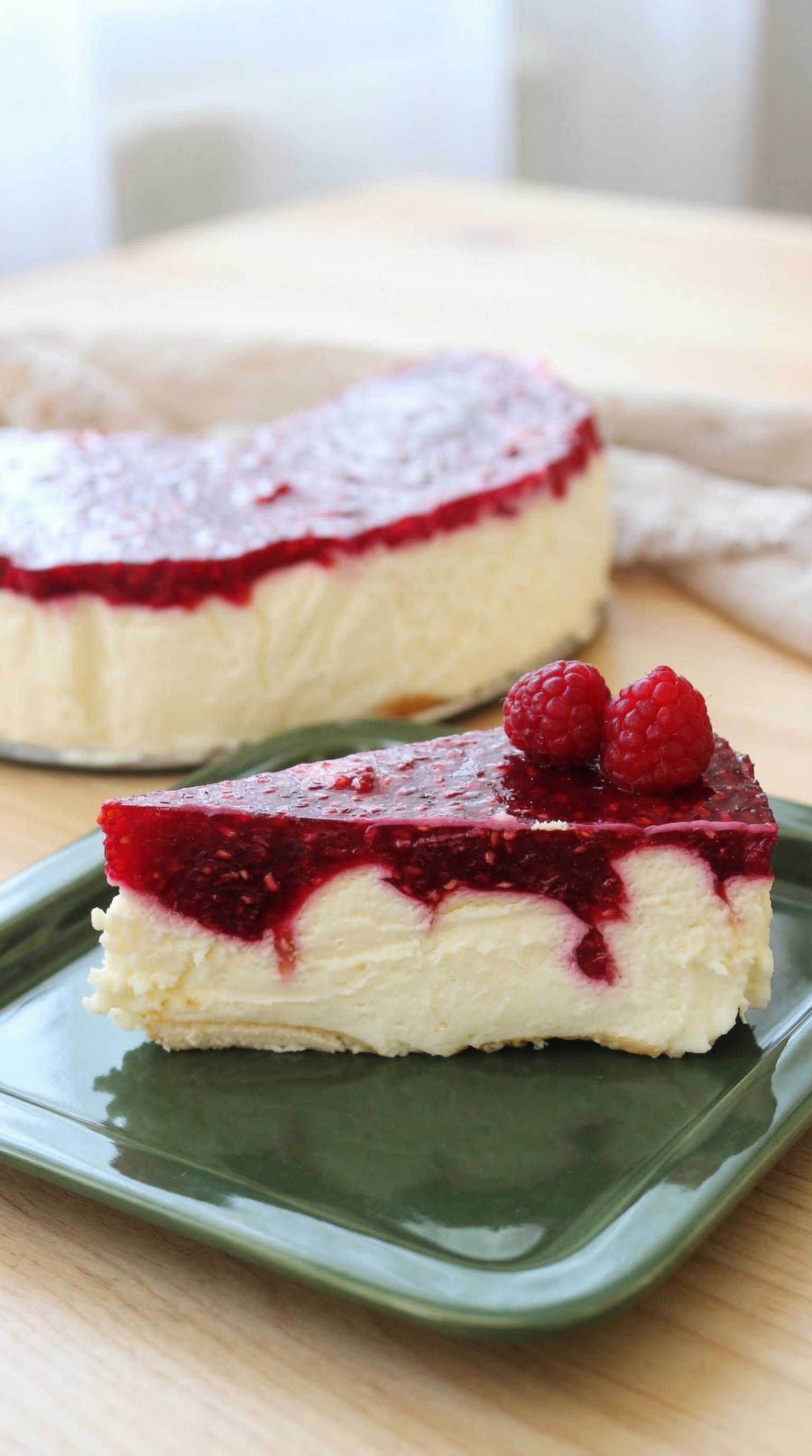 A slice of cheesecake with raspberries on top.