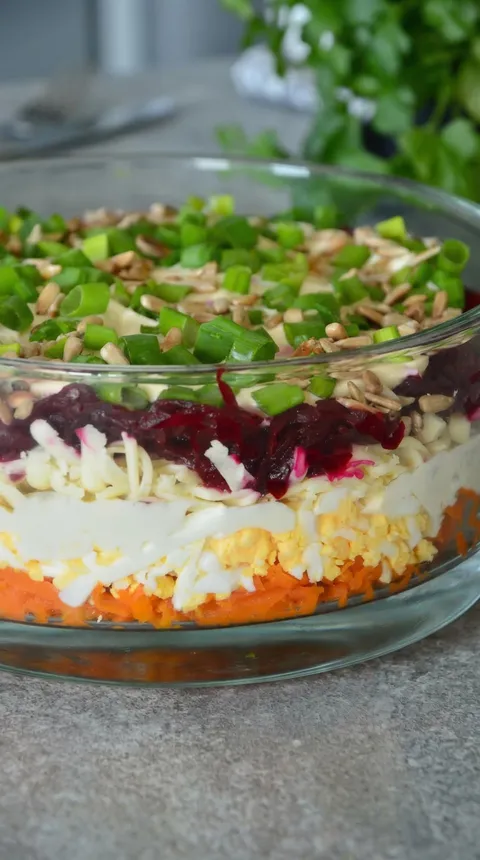 A bowl of salad with green peppers and carrots.