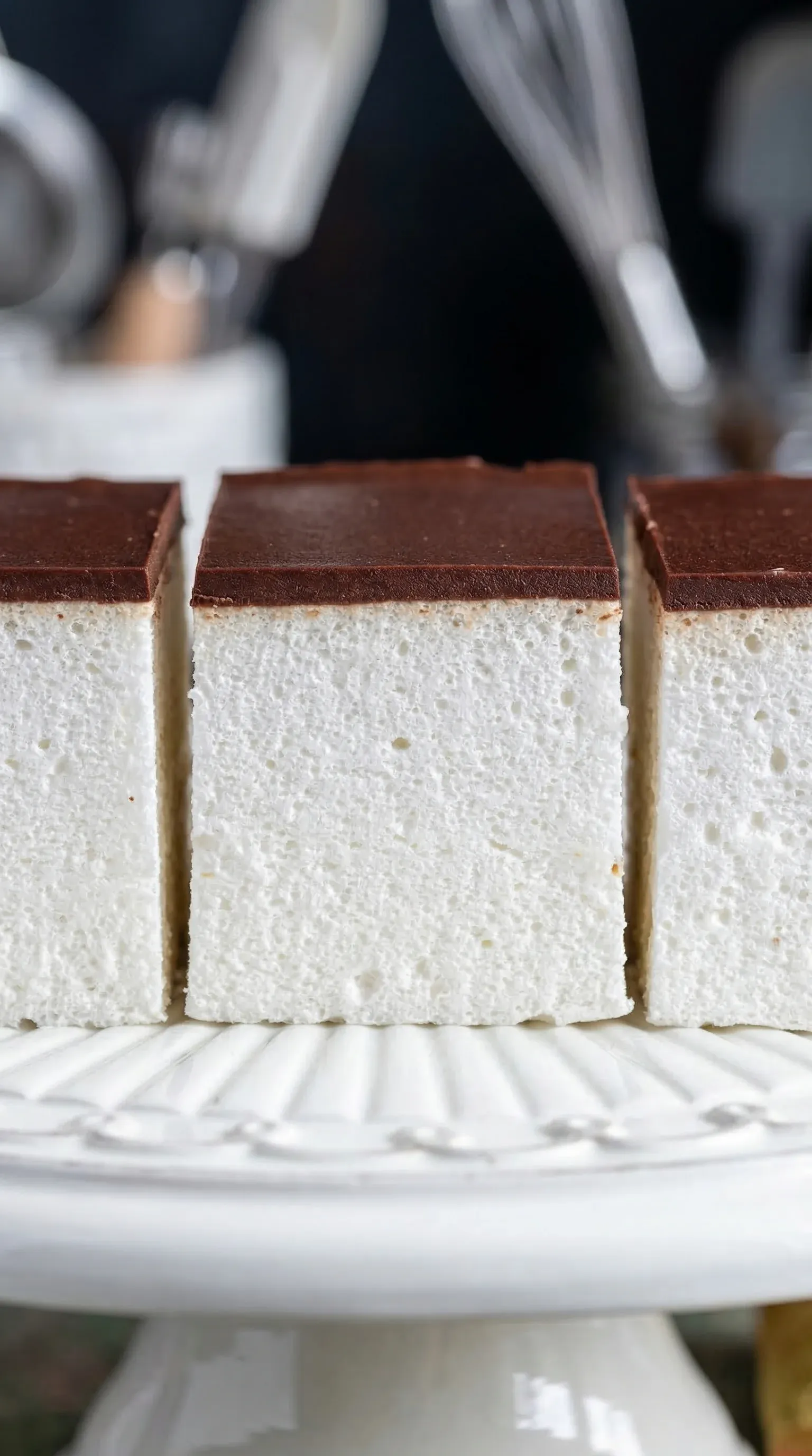 Three pieces of white cake with chocolate frosting.