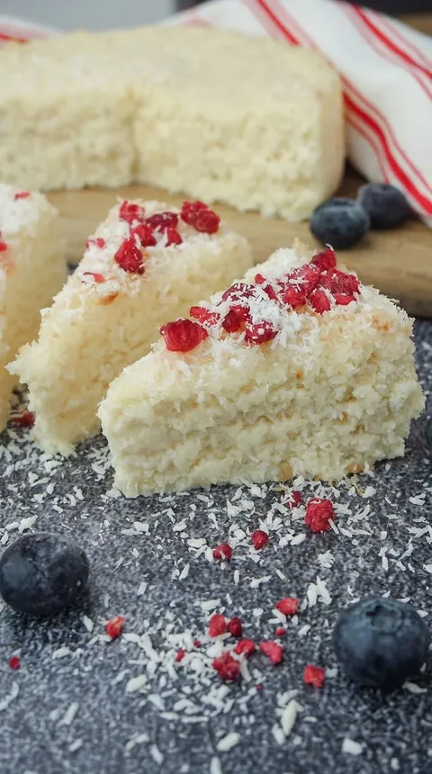 A slice of cake with red berries on top.