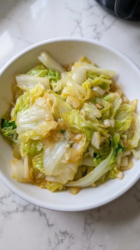 A bowl of cabbage with a sauce.