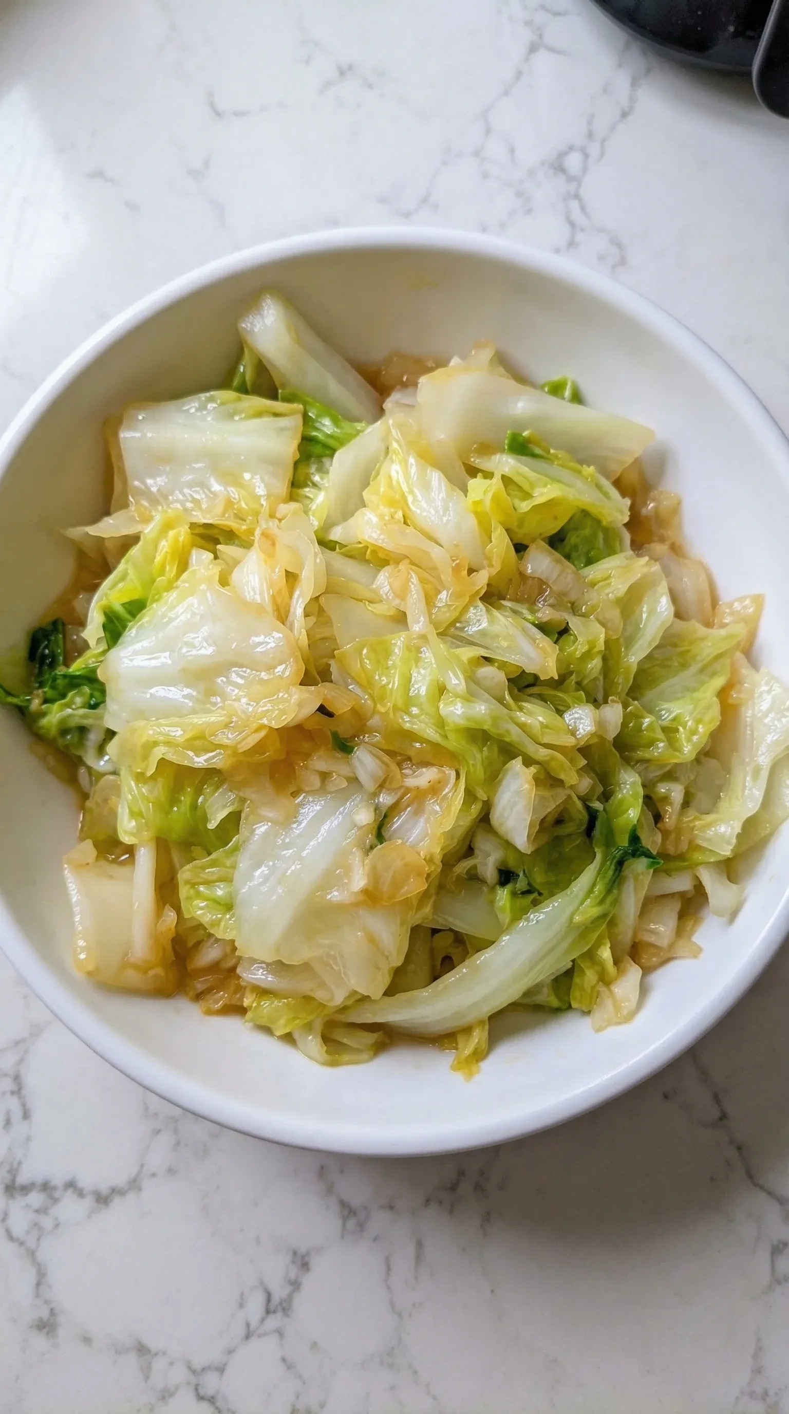 A bowl of cabbage with a sauce.