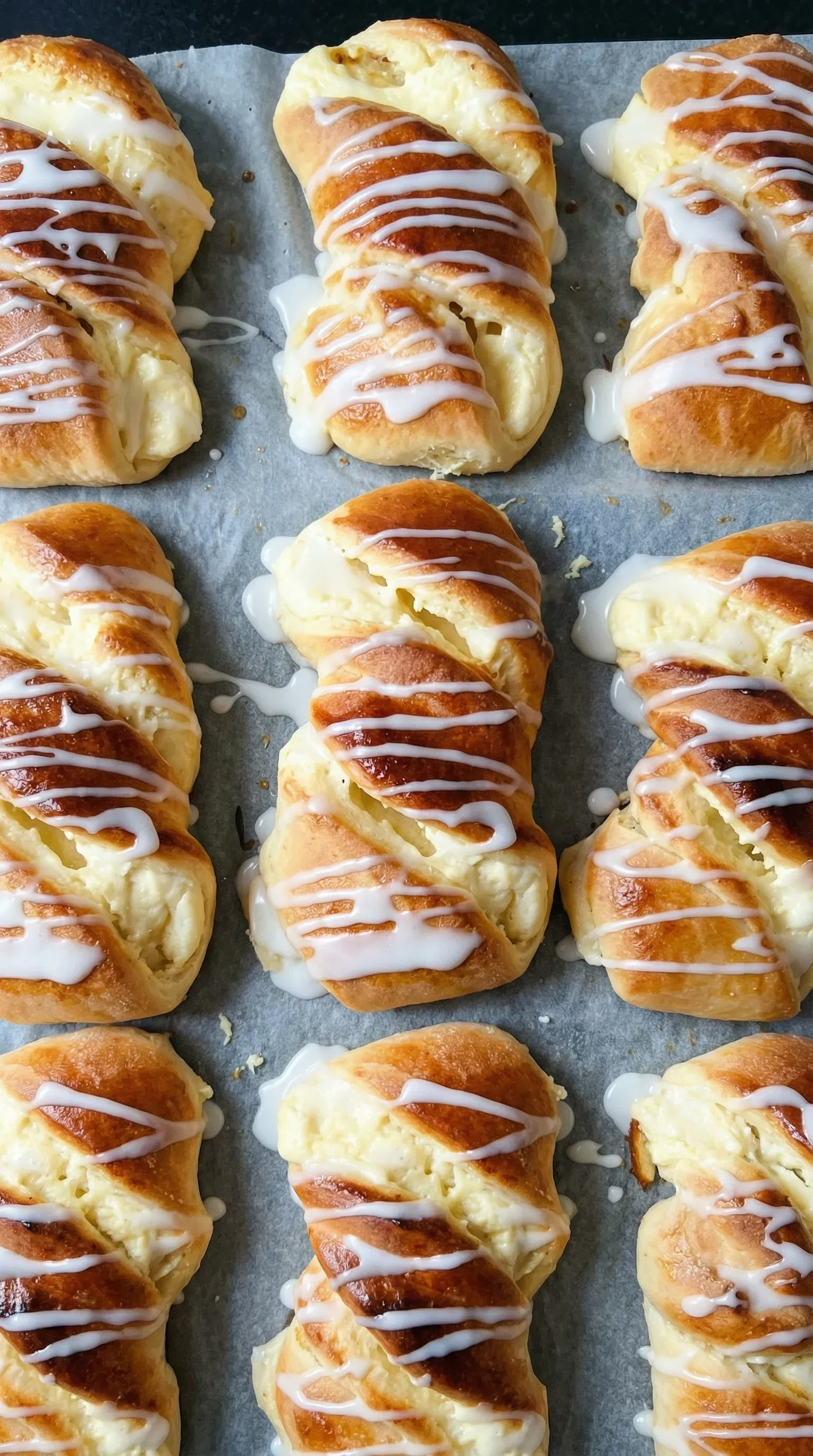 A tray of drożdżówki with white icing.