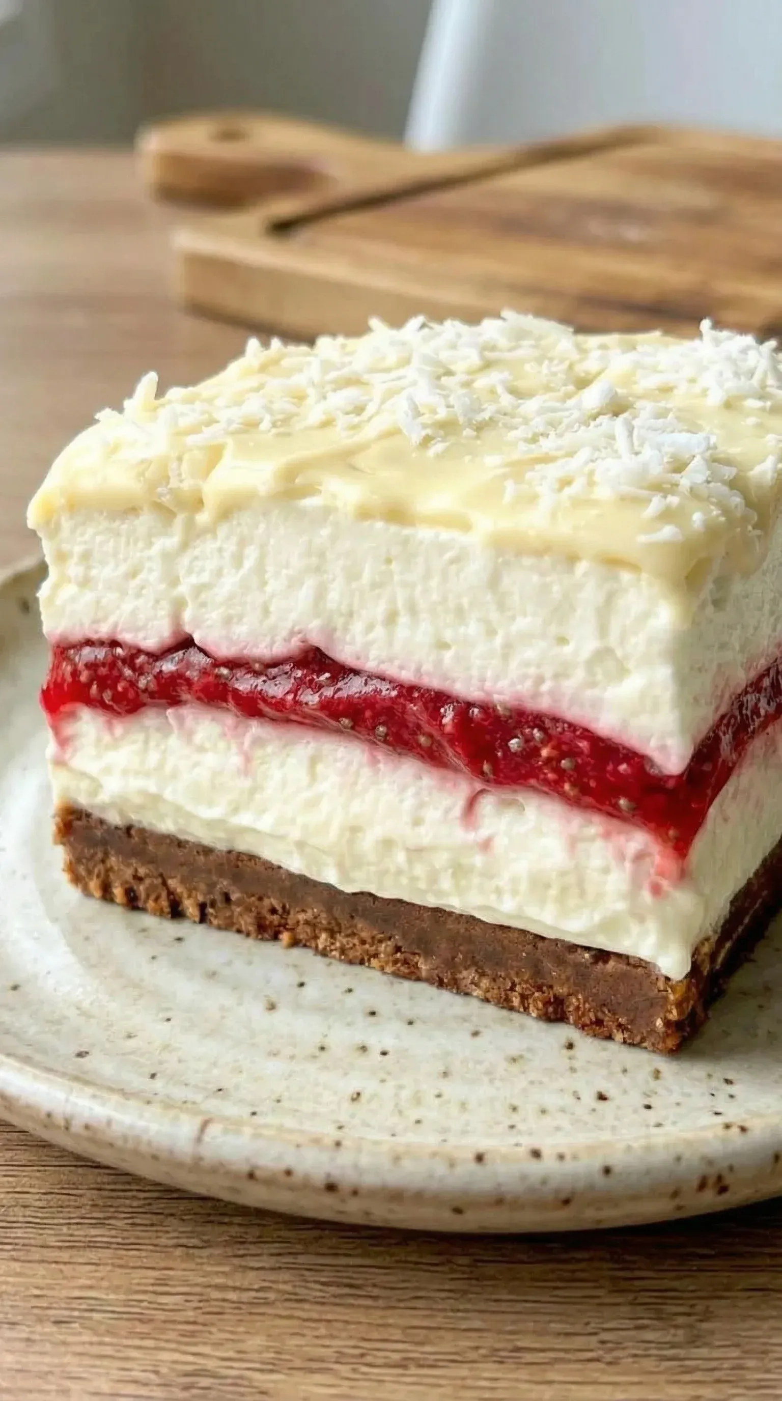 A slice of cake with red strawberry sauce.