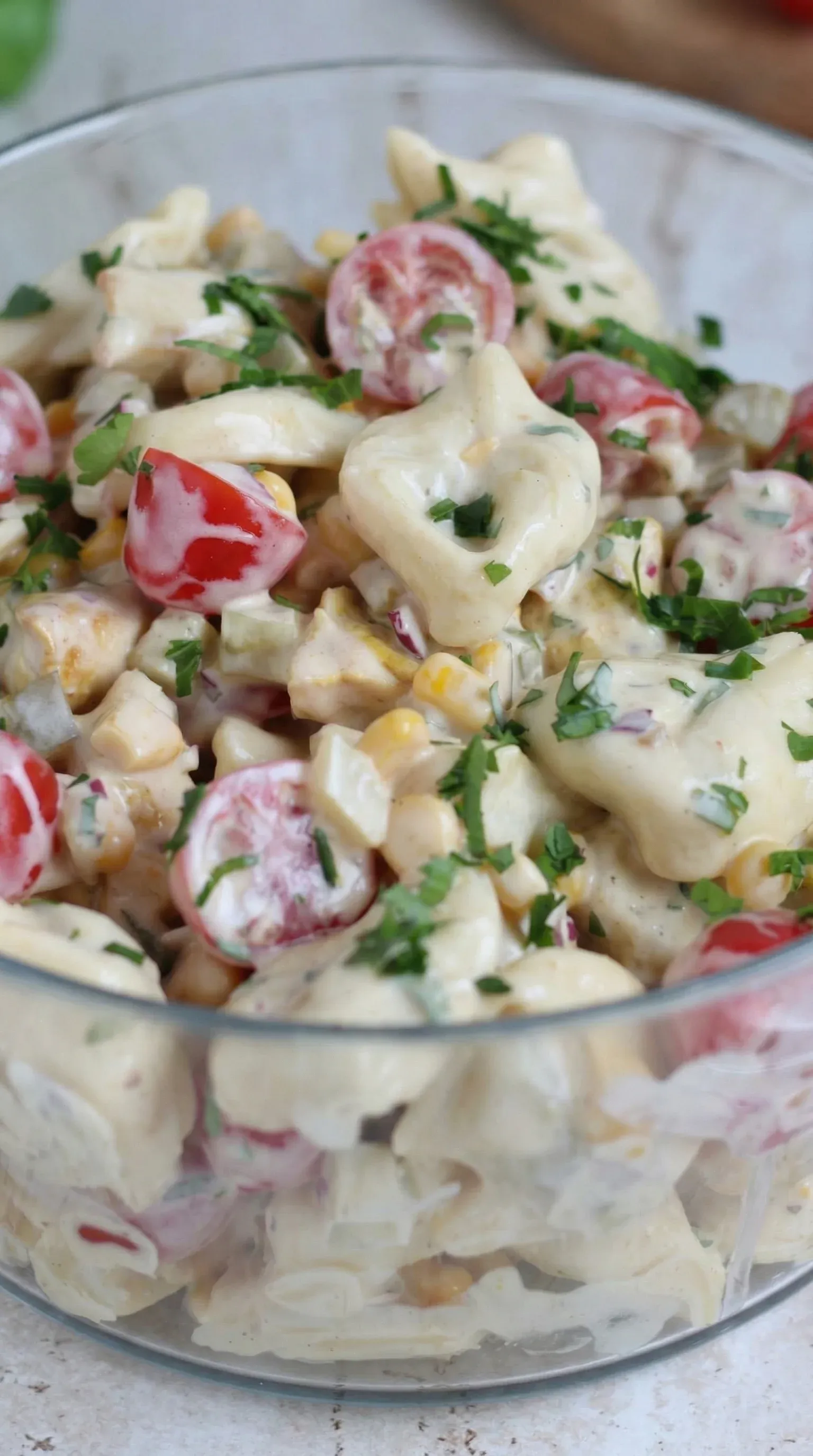 A bowl of salad with tomatoes, corn, and cheese.
