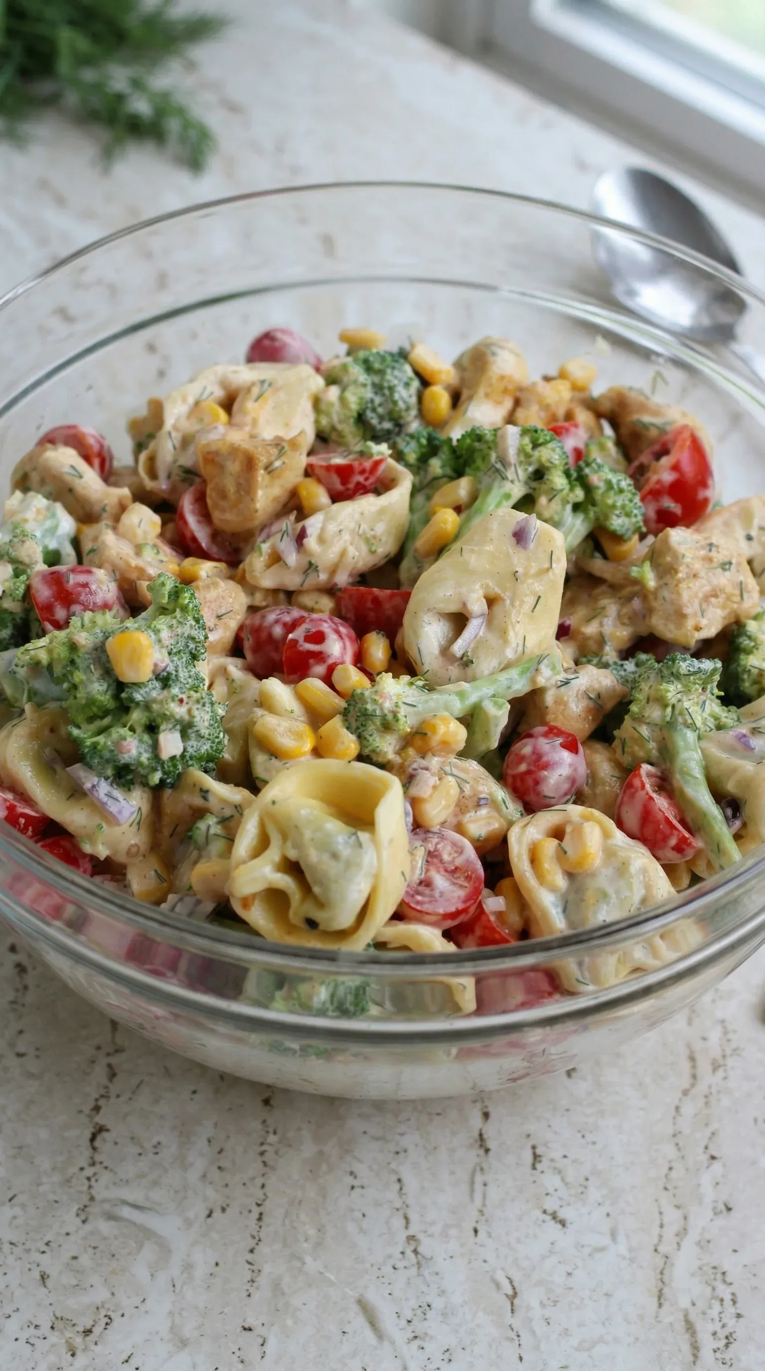 A bowl of food with pasta, broccoli, and tomatoes.