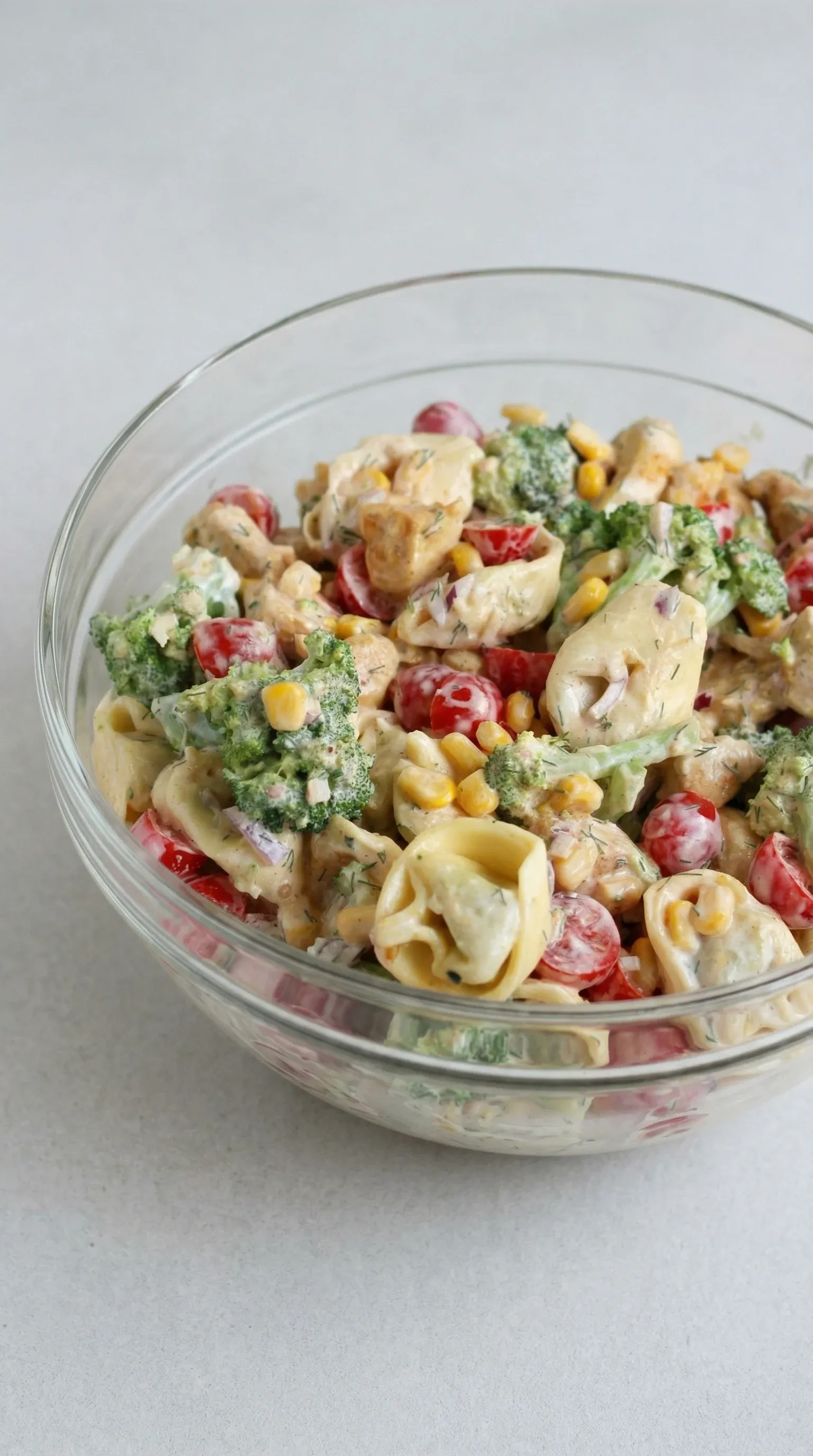 A bowl of salad with pasta and broccoli.