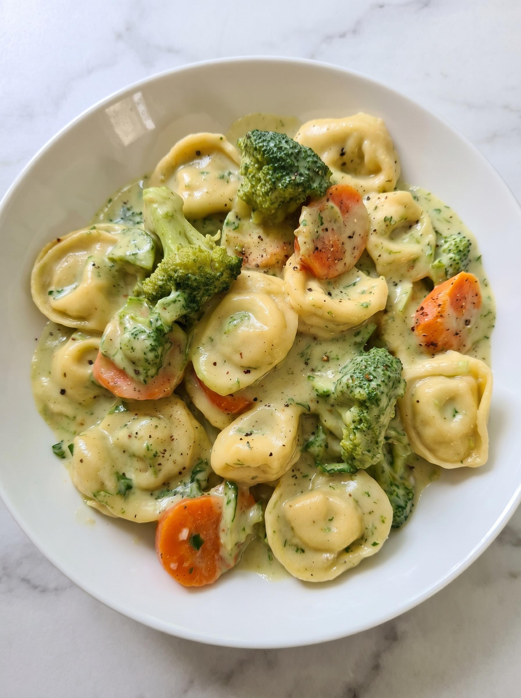 A bowl of pasta with broccoli and a creamy sauce.