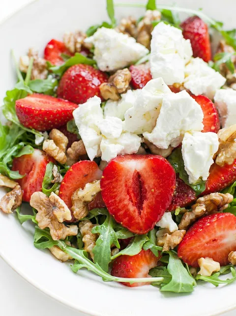 A salad with strawberries and walnuts.