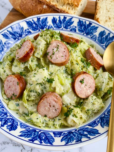 A plate of food with sausage and cabbage.