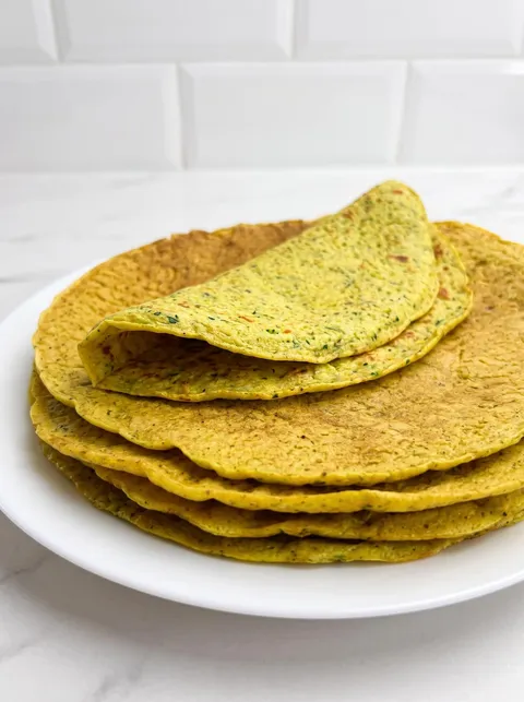 A plate of pancakes with green toppings.