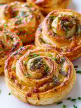 Two pieces of food with green toppings.