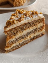 A slice of cake with nuts on top.