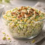 A bowl of pasta with chicken and corn.