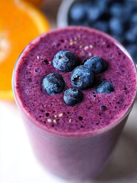 Szklanka smoothie jagodowego z jagodą w środku.