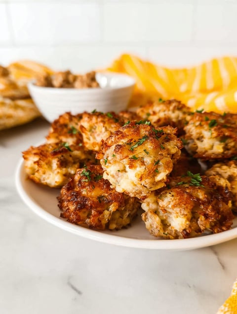 Talerz pełen chrupiących kąsków hashbrown z kiełbaską.