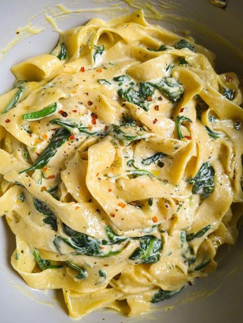 Miska makaronu ze szpinakiem i masłem czosnkowym.