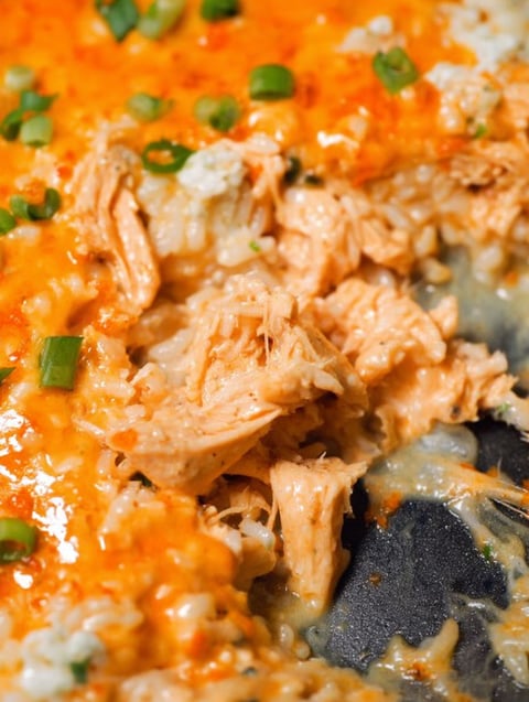 Zbliżenie na kawałek kurczaka w serowej zapiekance buffalo z ryżem.