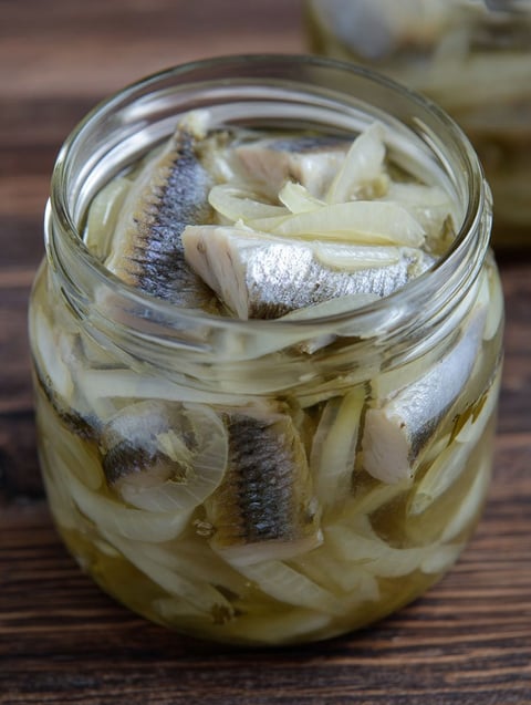 A jar of fish with onions.