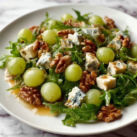 A plate of salad with grapes and walnuts.