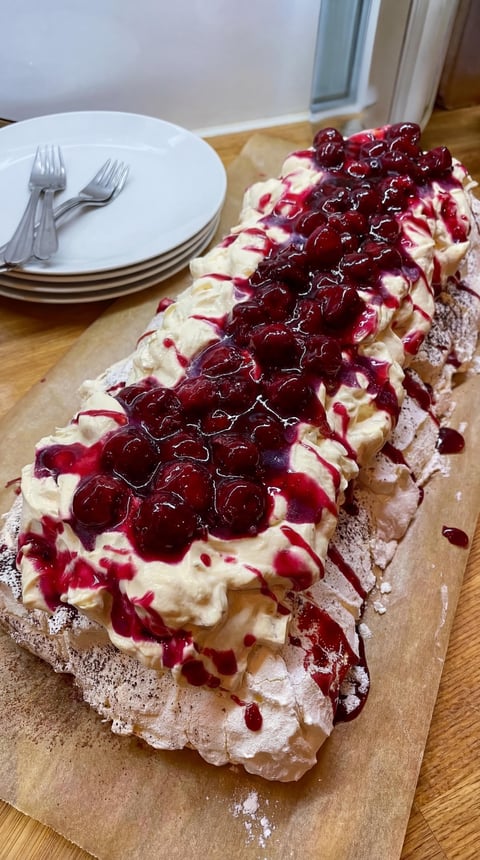 A dessert with berries and whipped cream.